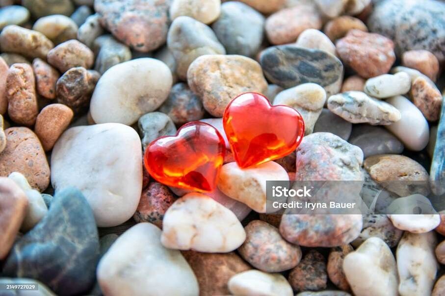 Glass red heart on the river pebble stones. - Lizenzfrei Freundschaft Stock-Foto